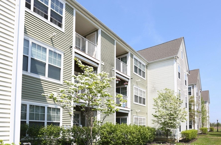 a row of apartment buildings with trees in front of them
