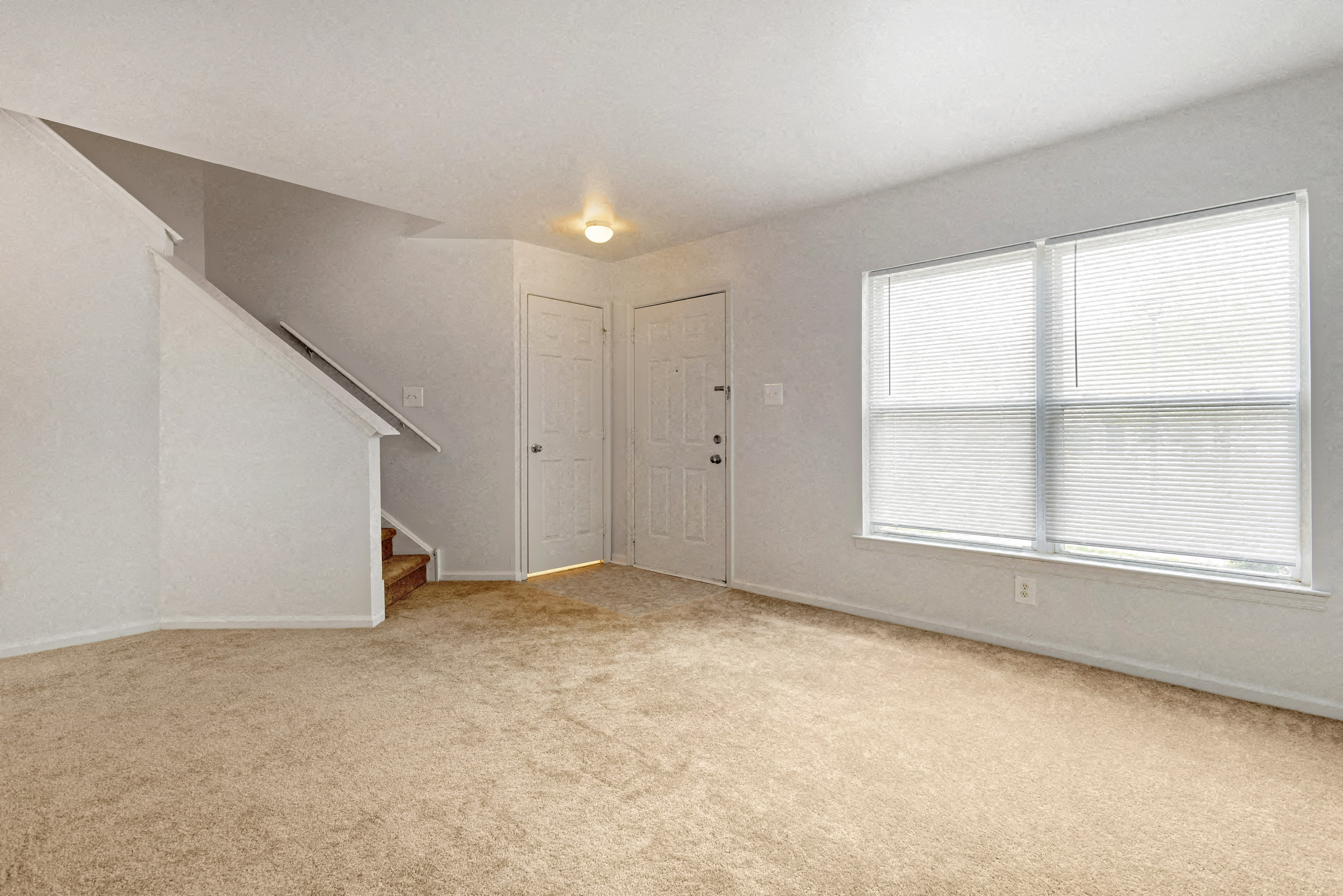 an empty room with a door and a large window