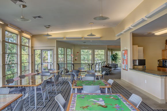 a large dining room with tables and chairs and windows