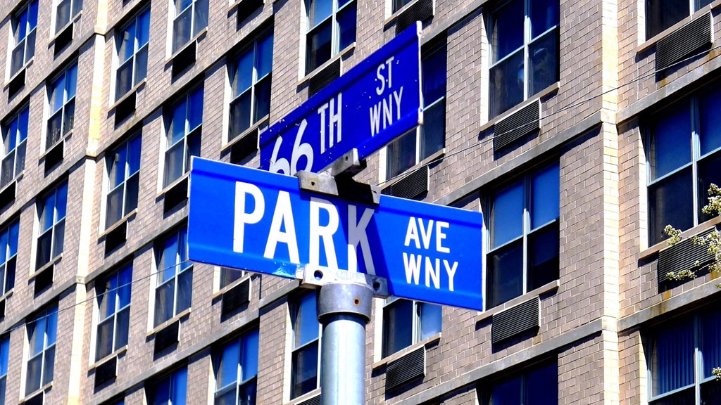 a couple of blue street signs in front of a building