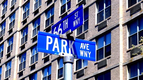 a couple of blue street signs in front of a building