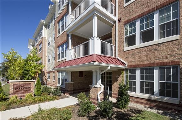 a brick building with a red roof and a balcony