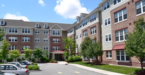 an exterior view of an apartment building with a parking lot