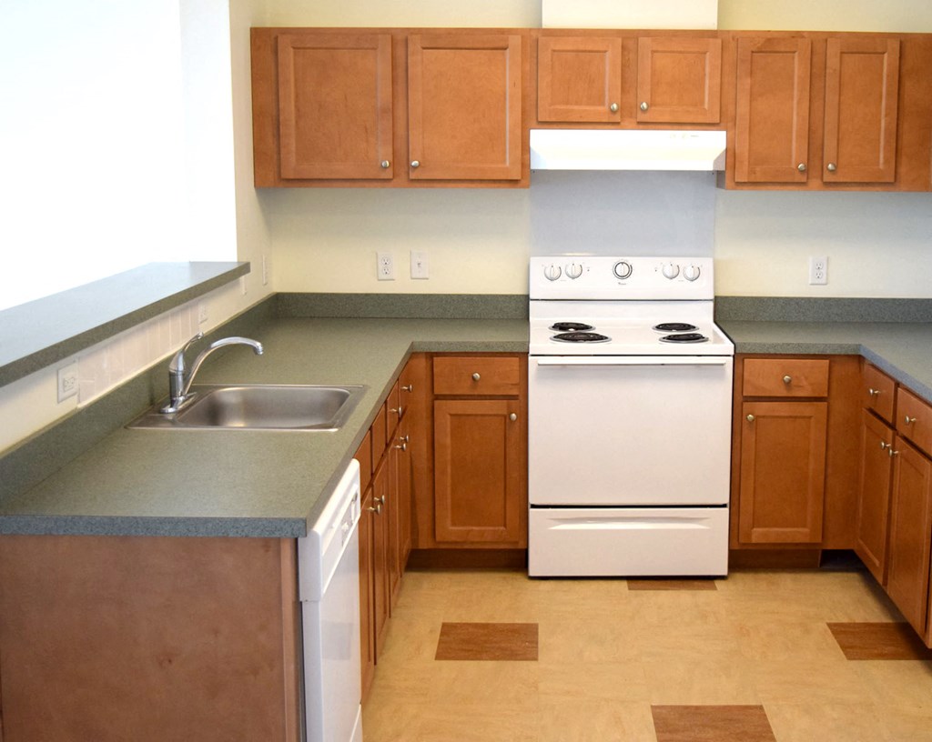 an empty kitchen with wooden cabinets and white appliances