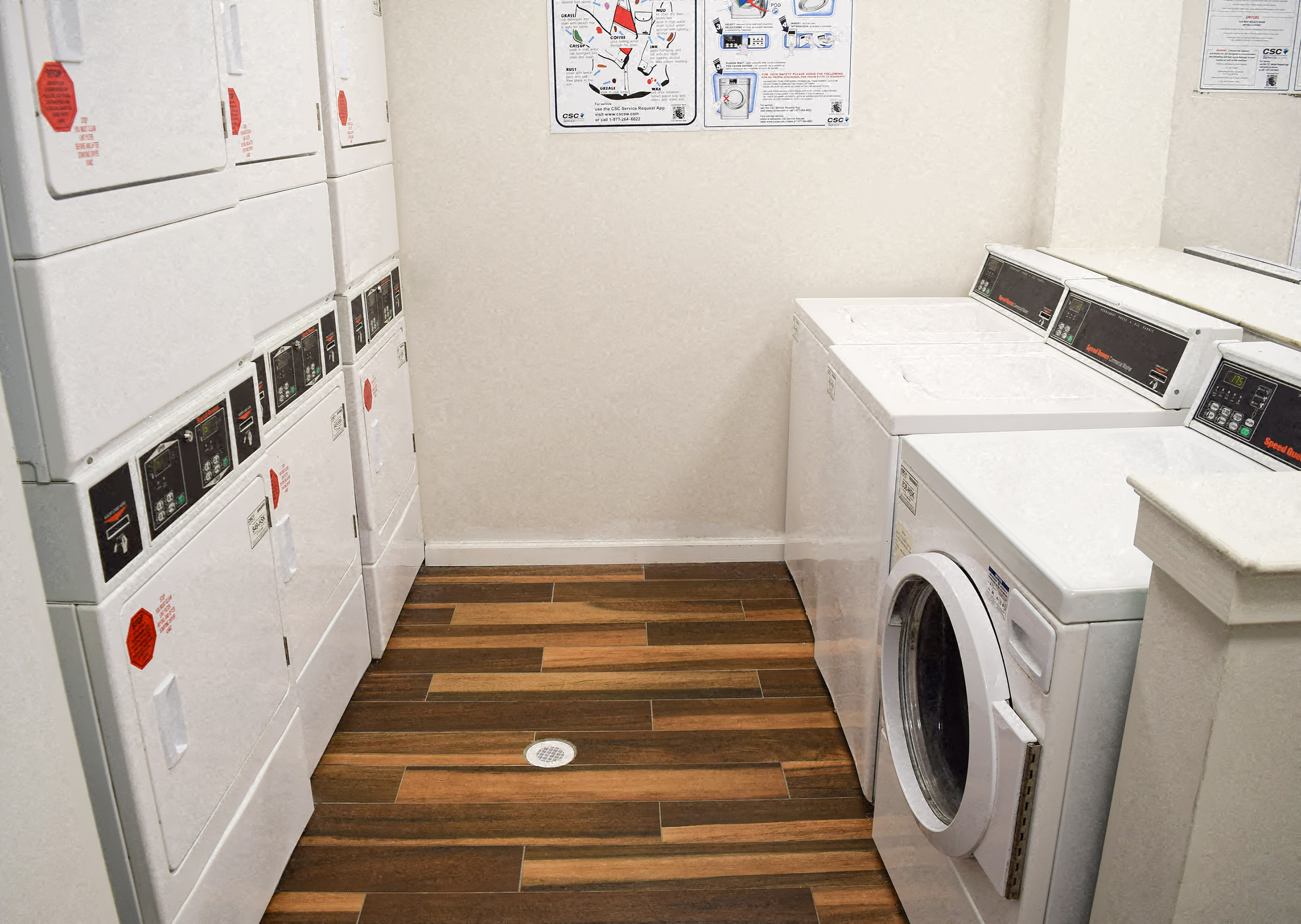 a washer and dryer in a laundry room with a wood floor