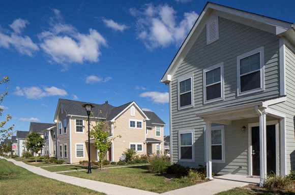 a row of houses on the side of a sidewalk