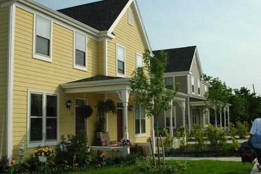 a yellow house with a porch and a yard