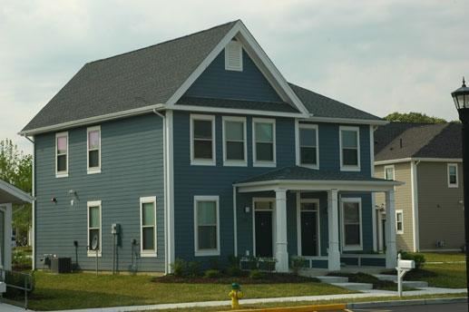 a blue house with a yellow fire hydrant in front of it