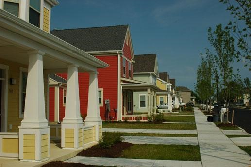 a row of red houses next to a sidewalk