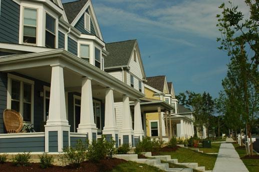 a row of houses with a sidewalk in front of them