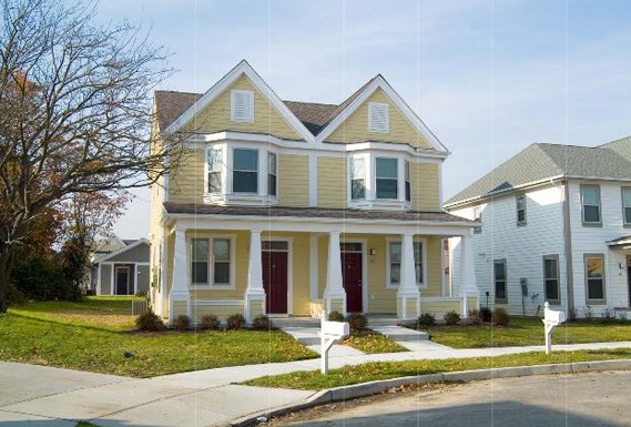 a yellow house with red doors and a sidewalk