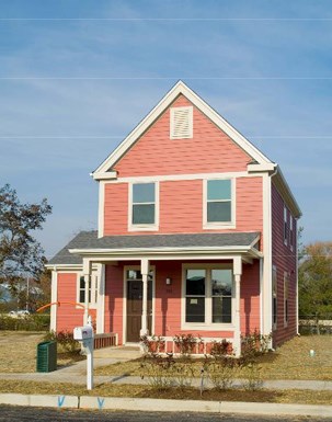 a red house with a parking meter in front of it