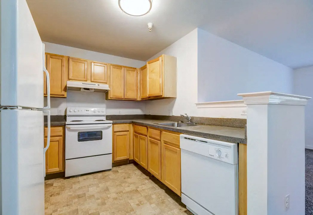 a kitchen with white appliances and wooden cabinets