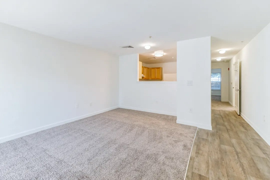 an empty living room with white walls and wood floors
