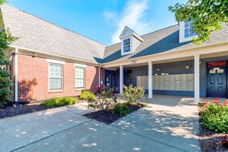 the front of a brick house with a driveway and a garage door