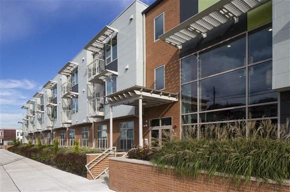 a row of buildings with large windows and a sidewalk