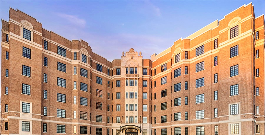 a large brick building with many windows and a blue sky
