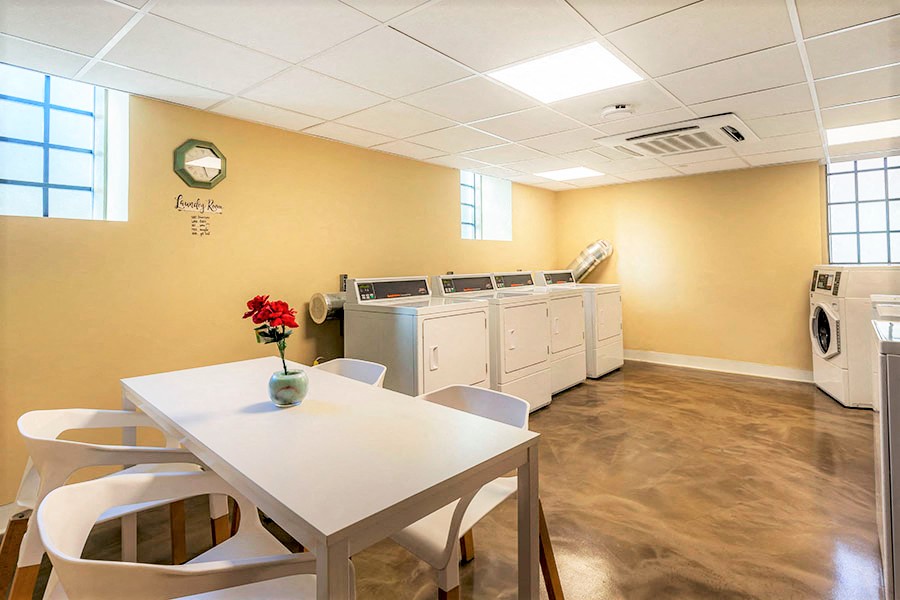 a laundry room with a table and chairs and washing machines