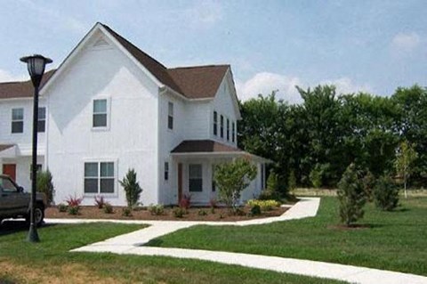 a white house with a truck parked in the driveway