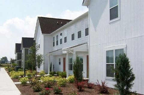 a white house with a garden in front of it