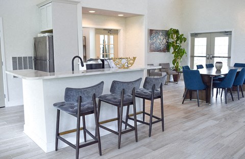A kitchen with a bar area and chairs.