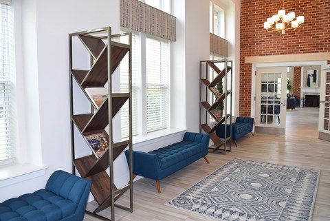 A living room with a blue couch and a bookshelf.