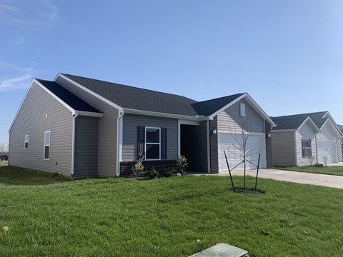 a gray house with a yard in front of it