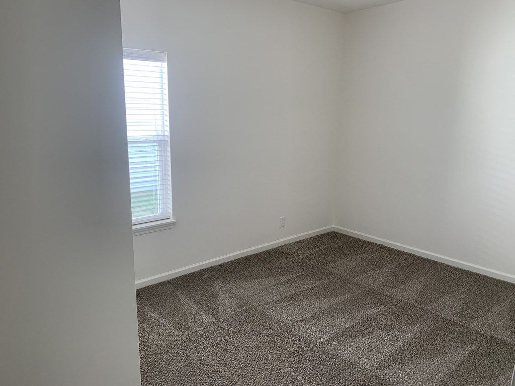 an empty room with carpet and a window