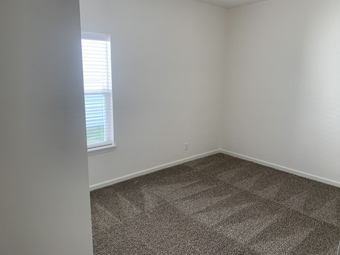 an empty room with carpet and a window