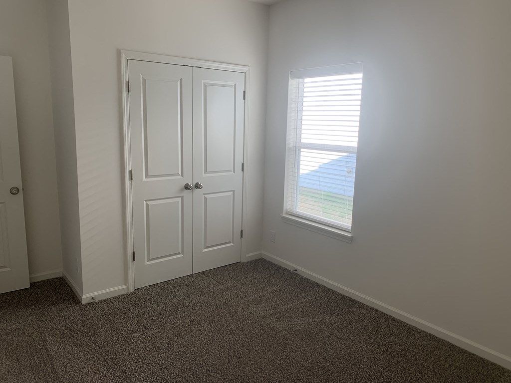 a room with a window and a door and a carpet