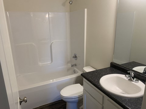a bathroom with a tub sink and toilet