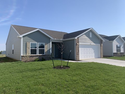 a house with a lawn and a tree in front of it