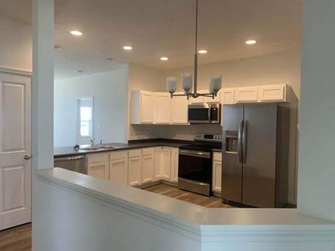 a kitchen with stainless steel appliances and white cabinets