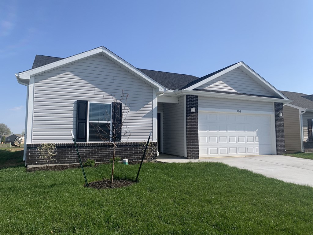 a house with a yard and a white garage door