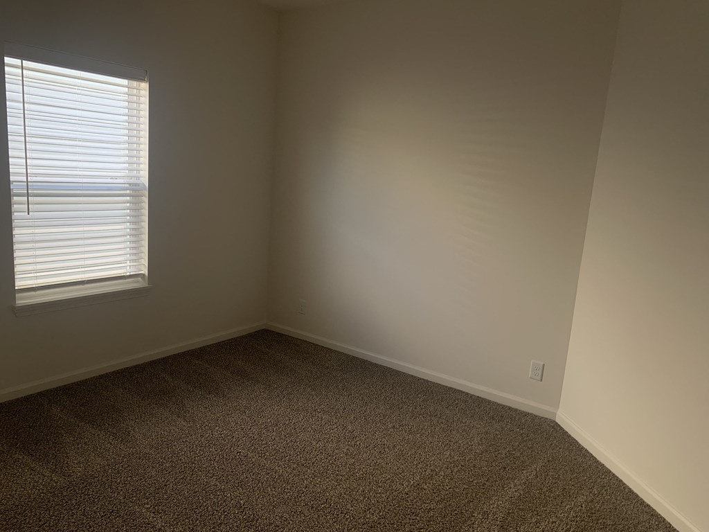 a small room with a window and a carpet
