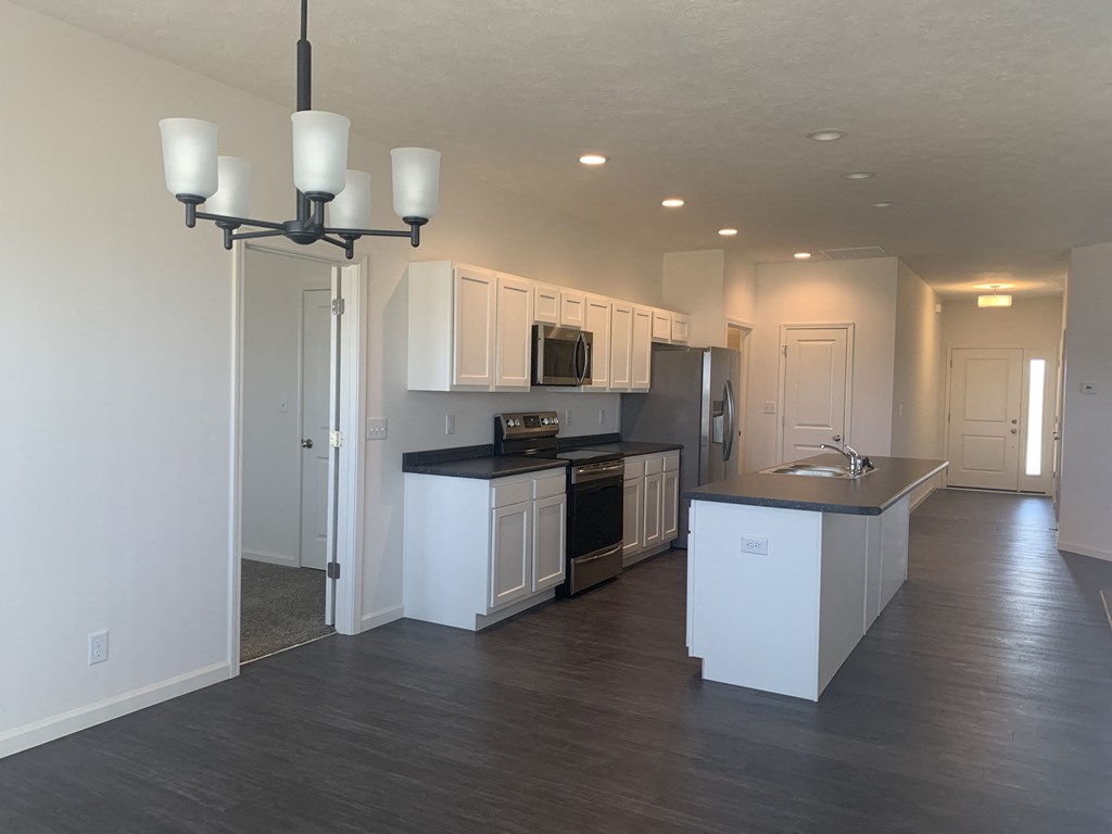 a kitchen with white cabinets and black counter tops