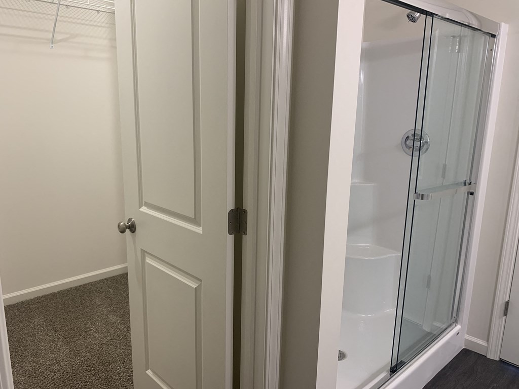 a white door with a glass shower in a bathroom