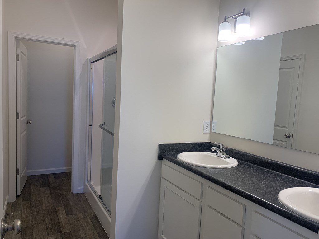 a bathroom with two sinks and a mirror and a shower