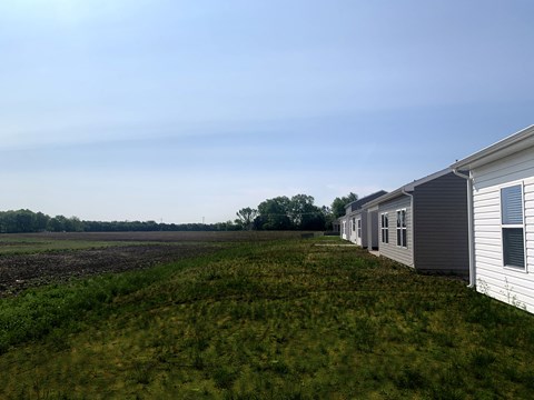 a row of rental homes next to a field