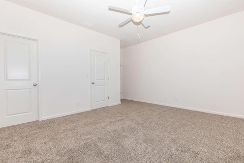 a bedroom with white walls and carpet and a ceiling fan