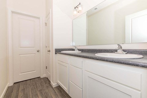 a bathroom with white cabinets and a sink and a mirror