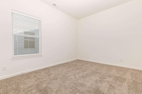 a room with a carpeted floor and a window