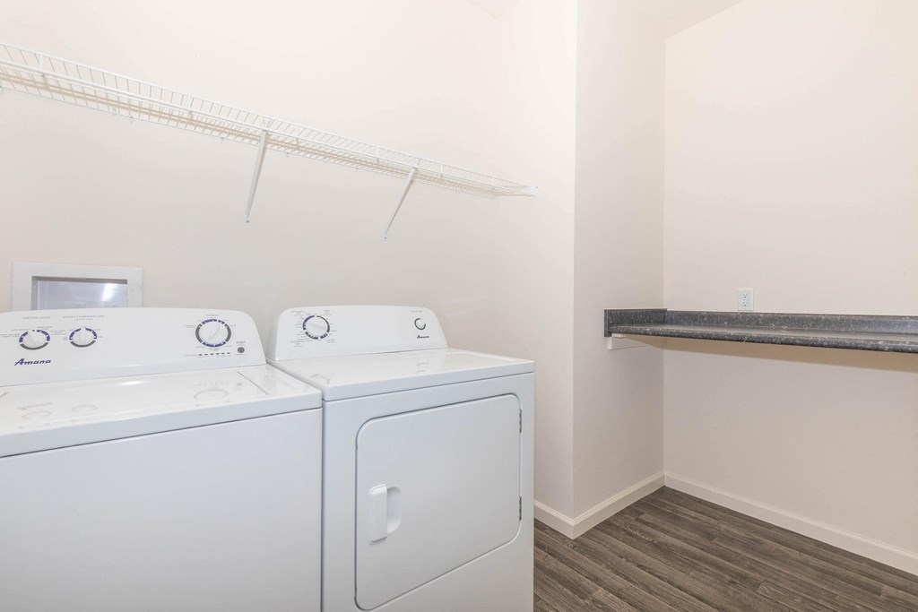 a washer and dryer in a room with a shelf and a dryer