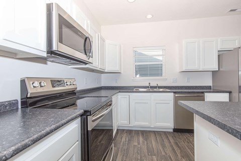 a kitchen with granite counter tops and white cabinets