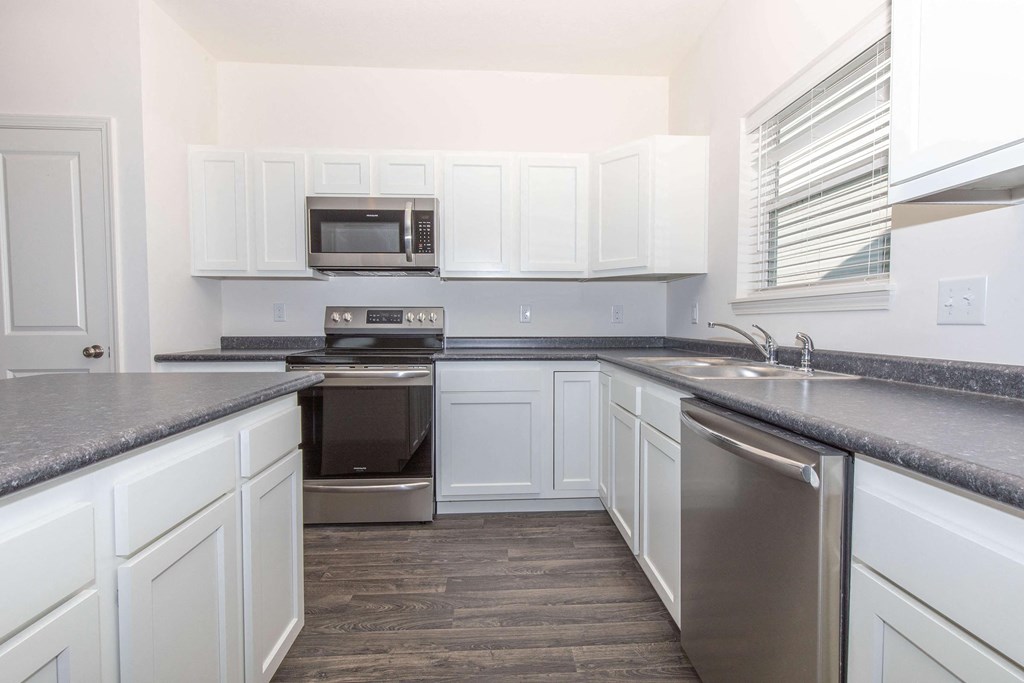 a kitchen with white cabinets and stainless steel appliances