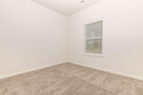 an empty room with carpet and a window