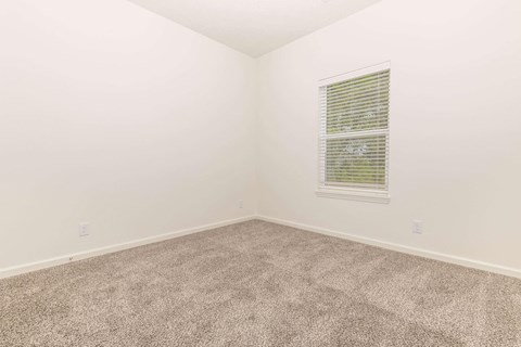an empty room with carpet and a window