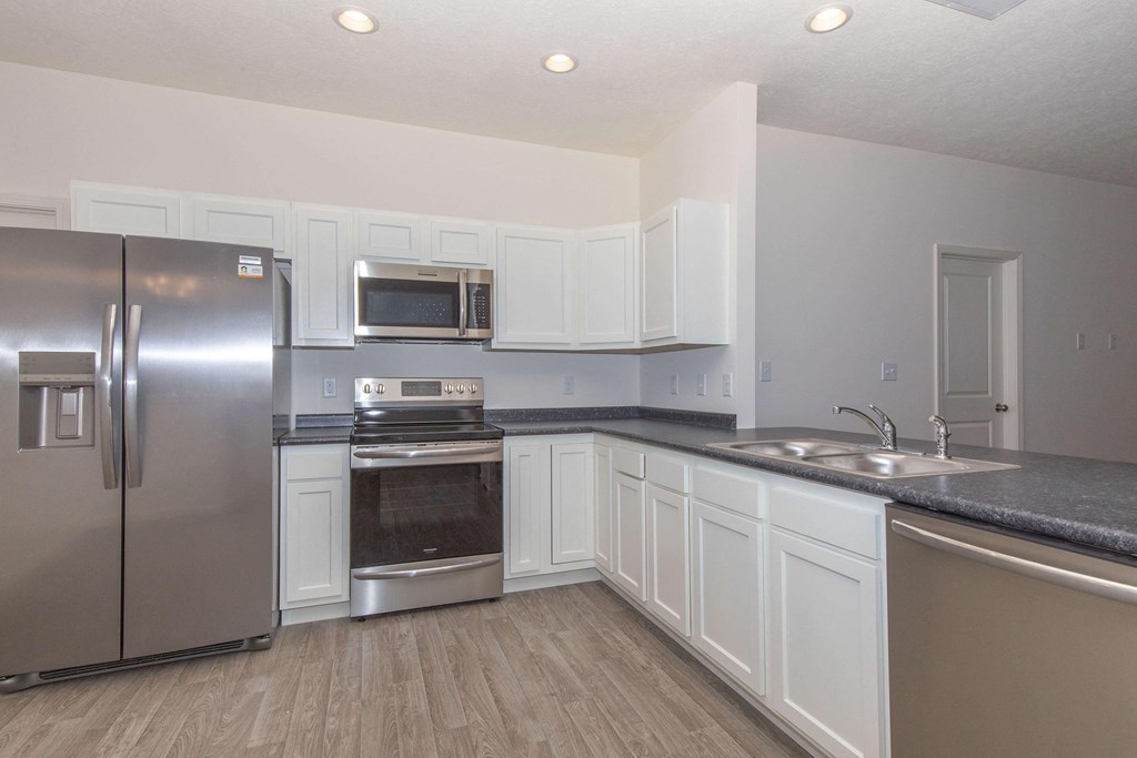 a kitchen with stainless steel appliances and white cabinets