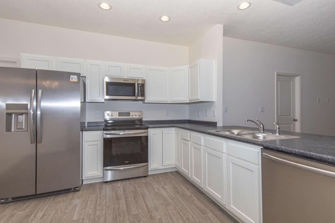 a kitchen with stainless steel appliances and white cabinets