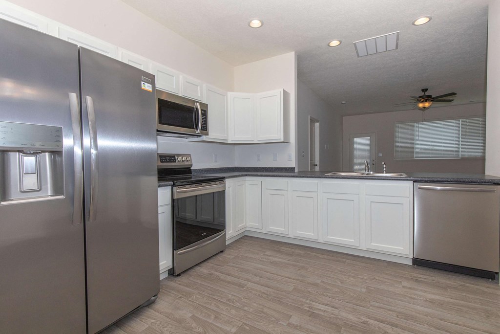 a kitchen with stainless steel appliances and white cabinets